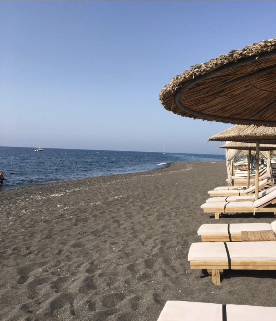 sunbeds on Perissa Beach, a black sand beach in Santorini Greece