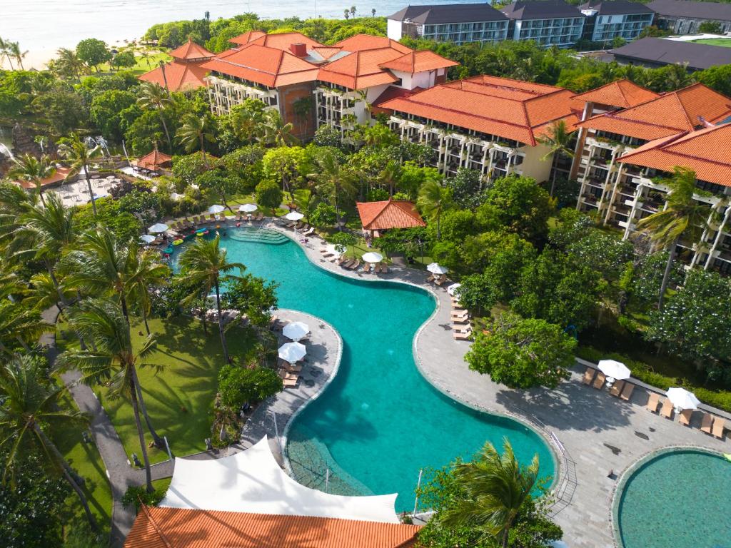 Aerial view of Ayodya Resort Bali in Nusa Dua featuring tropical gardens, lagoon-style swimming pools, palm trees, and traditional Balinese architecture near the beachfront.