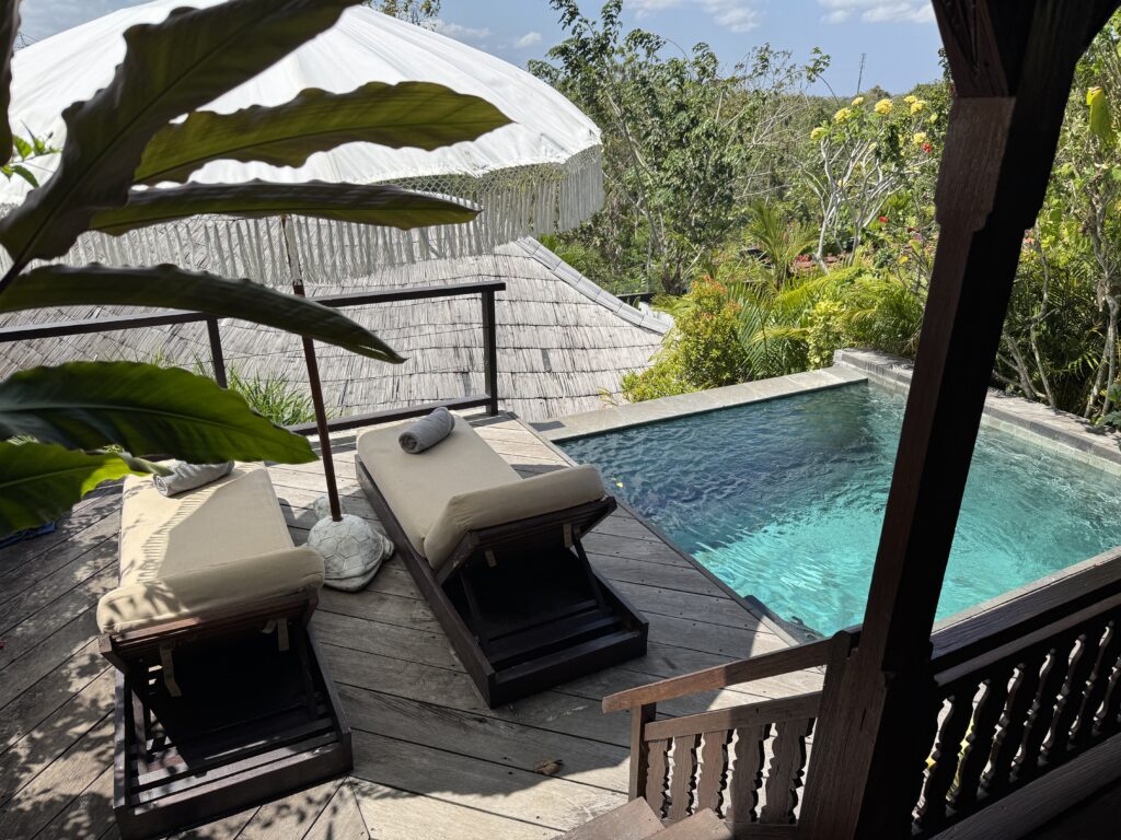 Private pool villa at White Tortoise Eco Villas in Uluwatu surrounded by tropical gardens with sun loungers and relaxing Balinese-style design.