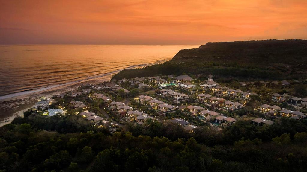 Best Honeymoon Resorts in Uluwatu, Bali - Sunset aerial view of Umana Bali resort in Uluwatu with luxury private villas, ocean views, and a romantic cliffside setting.